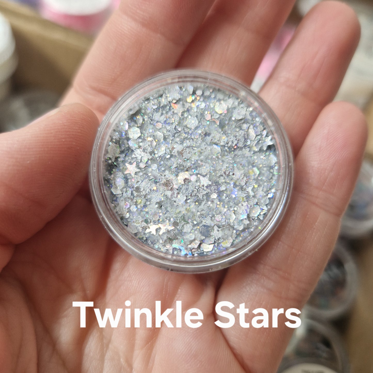 Twinkle Stars Glitter Cream i sølvhvid farve med stjerner og holografisk sparkle på hånd
