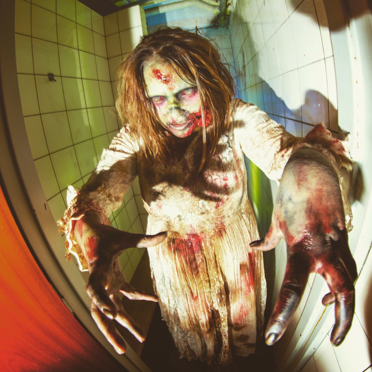 Zombiebrud, der går hen mod kameraet med fremstrakte arme og blod