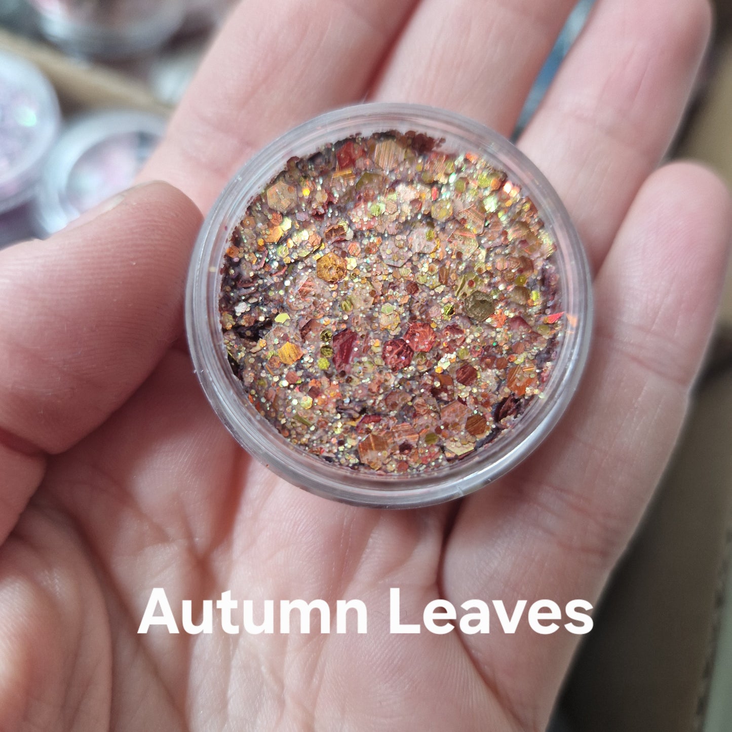 Autumn Leaves Glitter Cream i hånd - guldglitter makeup med rød og bronze sparkle effekt