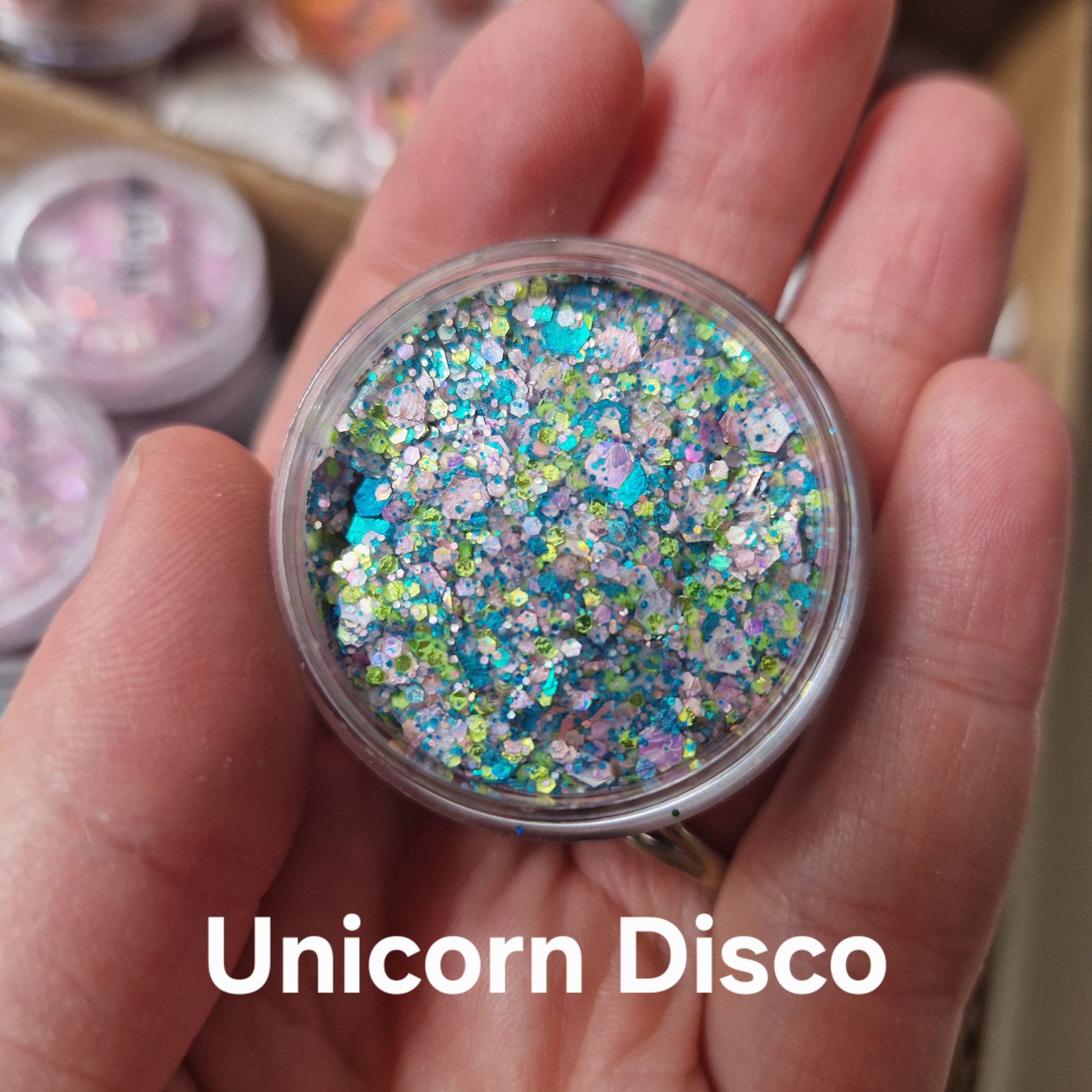 Unicorn Disco glitter cream i hånd - farverig glitter makeup med blå, grøn, pink og guldtoner fra Fusion Body Art