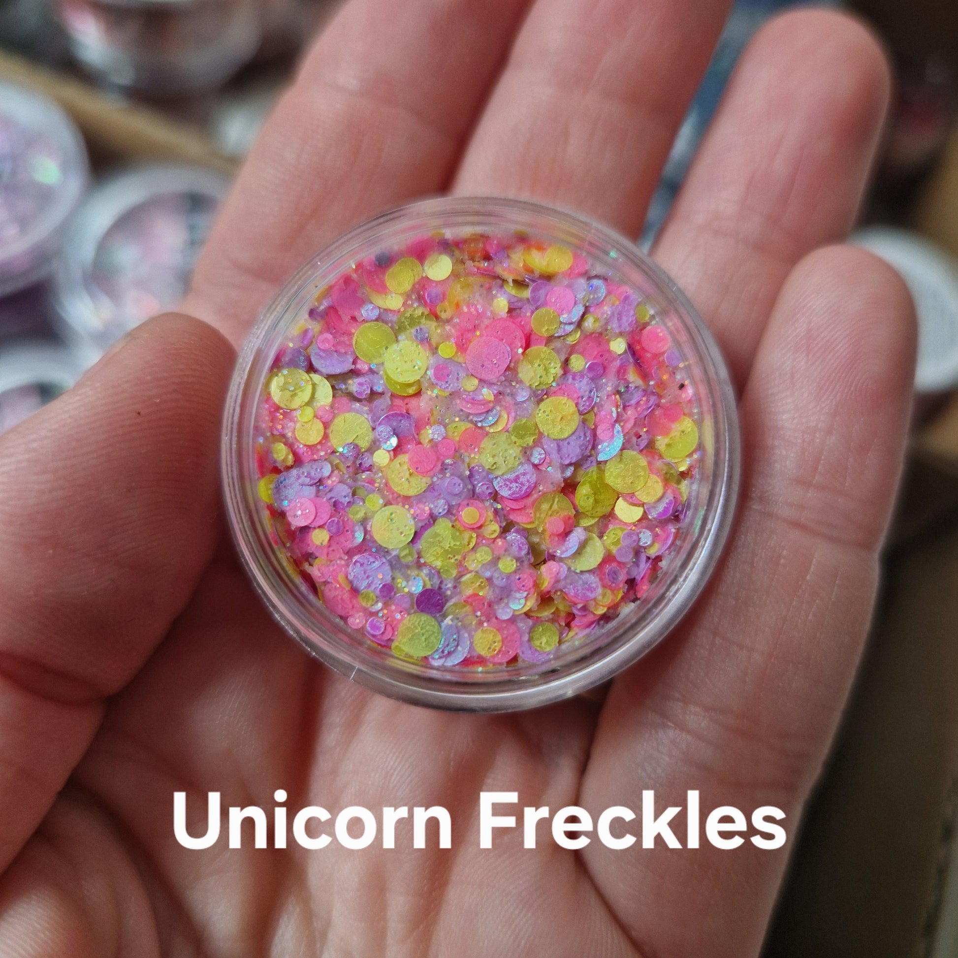 Unicorn Freckles glitter cream i pink, gul og lilla på hånd - glitter creme til makeup og ansigtsmaling